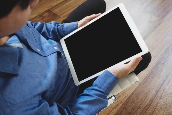 Egy férfi ül a székre, digitális tabletta számítógép Vágógörbe üres fekete képernyő — Stock Fotó