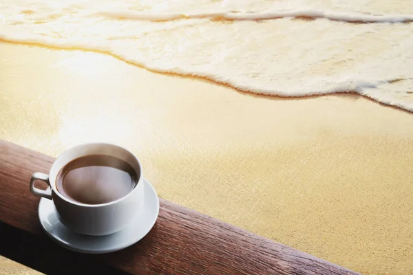 Copa de bebidas calientes de café en la mesa de madera, en la playa al amanecer — Foto de Stock