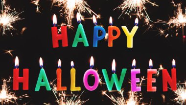 Renkli Cadılar Bayramın kutlu olsun mum metin ile siyah arka plan üzerinde maytap havai fişek