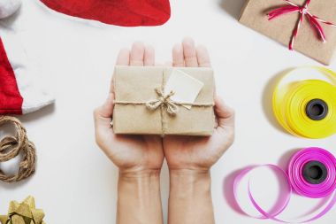 Parsel hediye kutusu, beyaz masa Noel günü için hazırlık Noel hediyesi tutan el