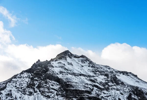 Hegy csúcsa a hó és a kék ég, fehér felhők télen, a téli táj, Izland — Stock Fotó