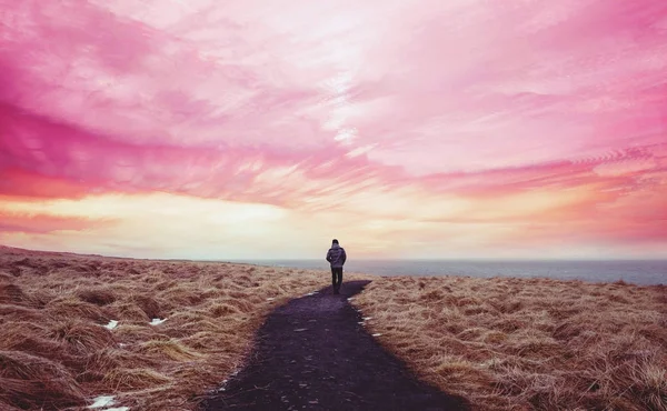 Farbenfrohe Landschaft, ein Mann, der allein auf dem Weg vorwärts mit buntem Himmel geht — Stockfoto