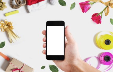 Mobil akıllı telefon, Noel ve Sevgililer dekorasyonu ile beyaz arka plan beyaz boş dikey ekran tutan el