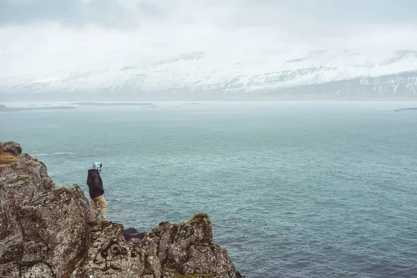 Un hombre parado solo en el acantilado en días lluviosos en Islandia — Foto de Stock