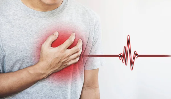 Un uomo che gli tocca il cuore, con un segno di battito cardiaco. Attacco di cuore, e altri concetti di malattie cardiache — Foto Stock