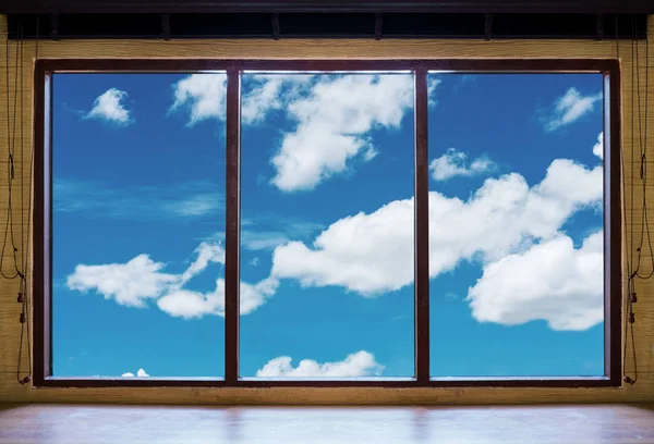 Looking through window, wooden window frames with blue sky and white clouds view