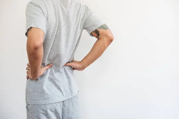 a man touching his back. Back pain, backache and waist pain, on white background