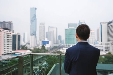Bangkok şehir, Tayland şehir görünümünde bakarak Balkonda duran genç işadamı