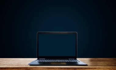 Bilgisayar dizüstü boş ahşap masa, koyu mavi zemin üzerine mavi ekran