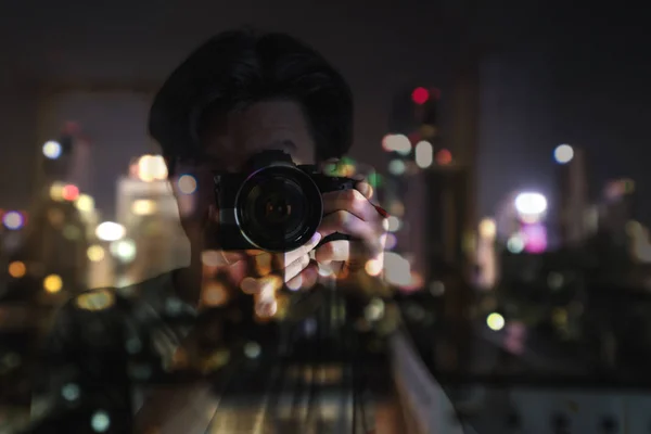 Człowiek Przy Zdjęciu Bokeh Światła Miasta Nocy Przez Aparat Cyfrowy — Zdjęcie stockowe