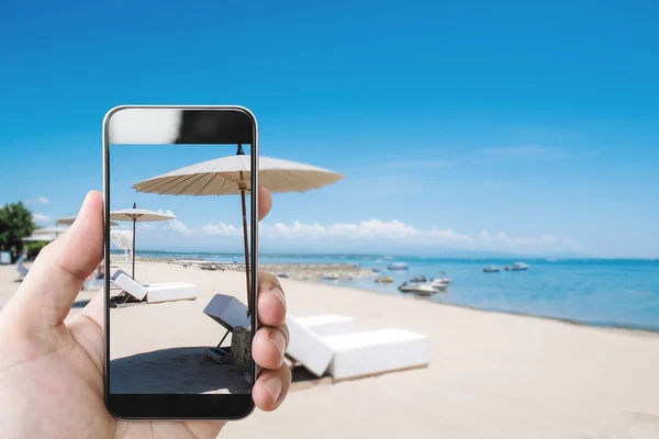 夏の休日 夏にビーチでモバイルのスマート フォンを持っている手 — ストック写真