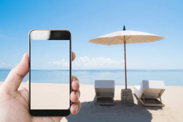 夏の休日 夏にビーチでモバイルのスマート フォンを持っている手 — ストック写真