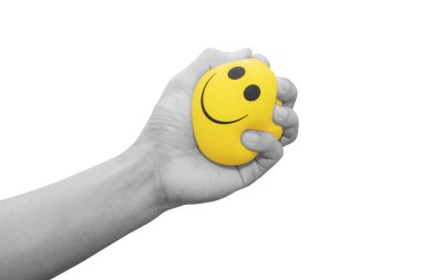 Hand squeezing smiling face yellow stress ball, isolated on white background clipart