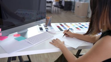 Çalışma masasındaki kağıt üzerine yaratıcı tasarımcı çizimleri ve çizimleri