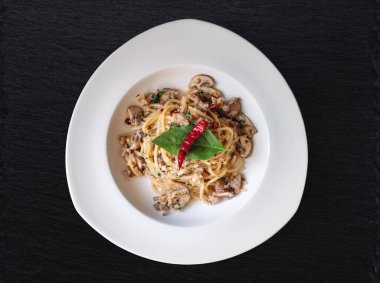 Kızarmış spagettiyi tuzlanmış balıkla, Tayland baharatlarıyla ve kuru biberle karıştır.