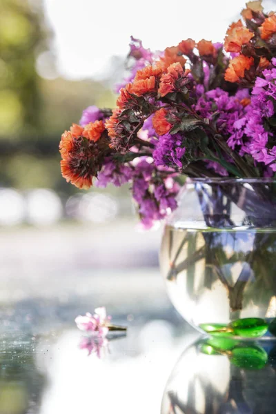 Cam bir masadaki vazoda kurumuş çiçekler.