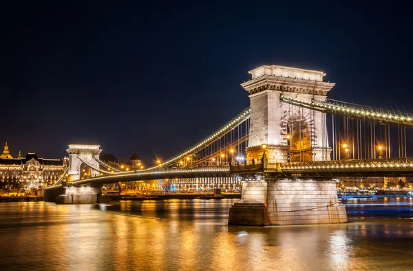 มุมมองกลางคืนของสะพานโซ่ Szechenyi เป็นสะพานแขวนที่ครอบคลุมแม่น้ําดานูบระหว่างบูดาและพีท, ฮังการี . — ภาพถ่ายสต็อก