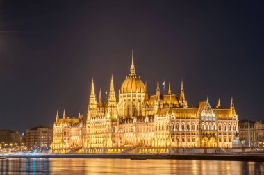 Macaristan 'ın Budapeşte kentindeki Tuna Nehri kıyısındaki Macar Parlamentosu binasının gece manzarası