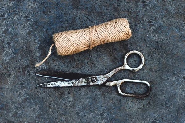 Uma corda de cordel e tesoura velha em uma pedra em um jardim — Fotografia de Stock
