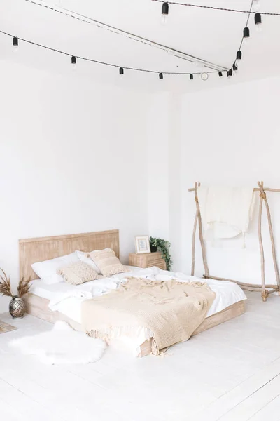 Bright loft-style bedroom with a bed and a plaid blanket