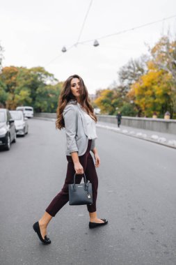 Profesyonel makyajlı ve yolda koşan genç bir kız.