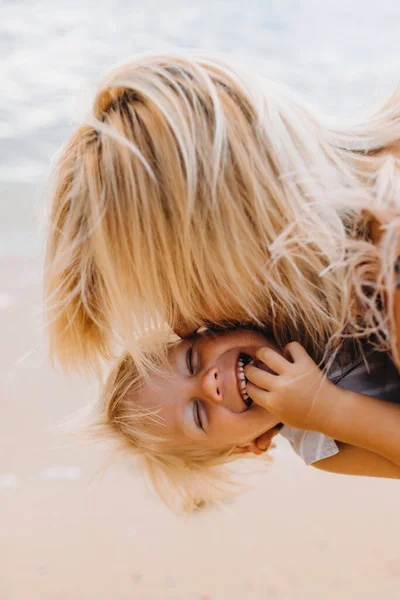 Šťastná maminka na dovolené objetí a polibky její smích syn — Stock fotografie