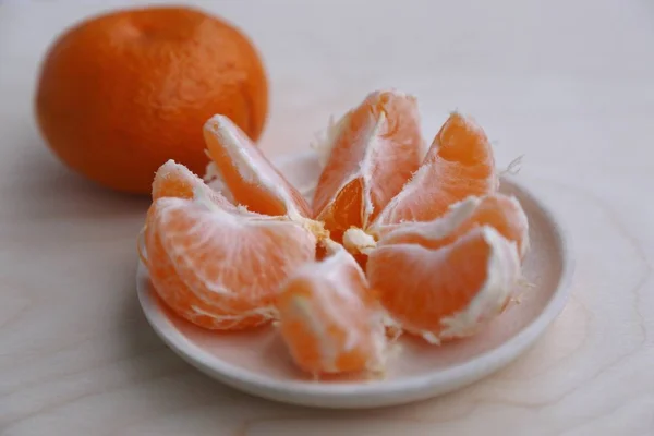 many  pieces of  mandarin  orange  on  the  plate  and  one  mandarin fruit