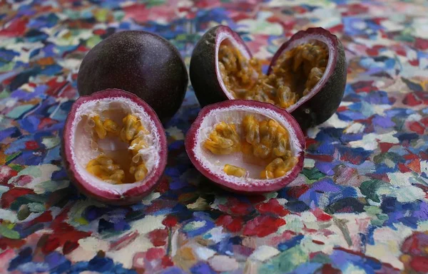 Maracuya fruit with lilac skin and cut into two equal parts, inside flesh and juice, teaspoon on napkin side view