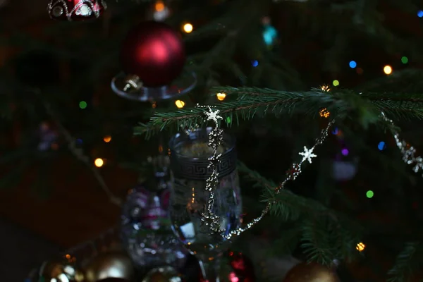 ガラスのトレイで金色の小さなボールで作られたガラスとリボンで作られたクリスマスのおもちゃ 白ワインのガラスで新年はまだ人生 — ストック写真