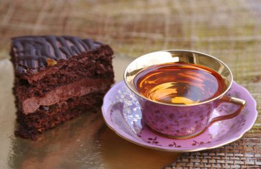 Bir parça çikolatalı kek ve bir fincan çay.