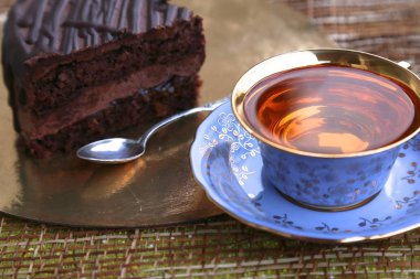 Bir parça çikolatalı kek ve bir fincan çay.