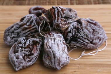 Kurutulmuş hurma şekerleri şeker tozu serpiştirilir, yan tarafından ip ile bağlanır.