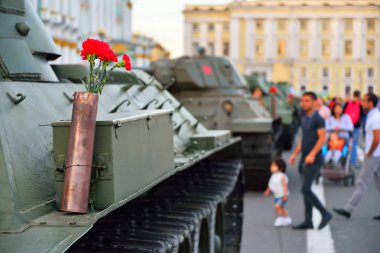 Ağır bir Sovyet tankının üzerindeki silah fişeğindeki kırmızı karanfiller.