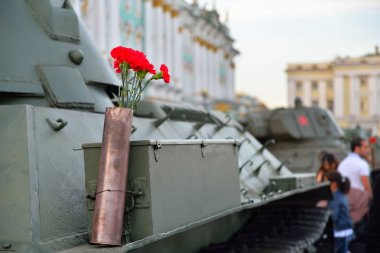 Ağır bir Sovyet tankının üzerindeki silah fişeğindeki kırmızı karanfiller.