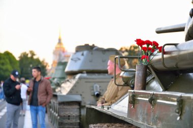 İnsanlar yürüyüş ve bir silah kartuşundaki Orta kırmızı karanfiller