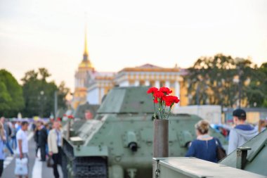 Bir silah kartuşundaki orta Sovyet tank T-34 o kırmızı karanfiller