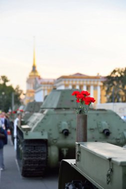 Orta boy Sovyet tankı T-34 'ün üzerindeki bir silah kartuşunda kırmızı çiçekler.