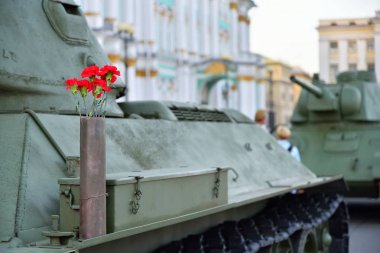 Bir silah kartuşundaki Sovyet tank ortasında kırmızı çiçekler