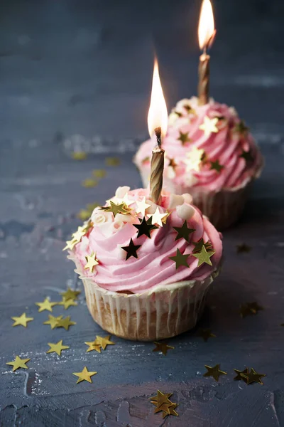Two pink cupcakes with candles and confetti — Stock Photo, Image