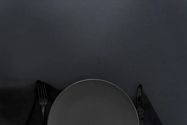 Placa oscura, cuchillo negro y tenedor — Foto de Stock