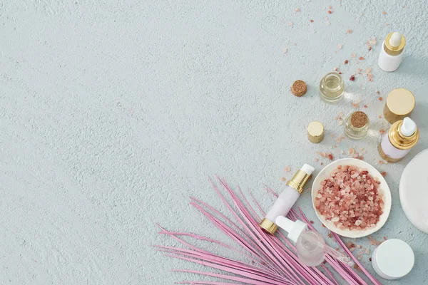 beauty skincare products with pink palm leaf on white background