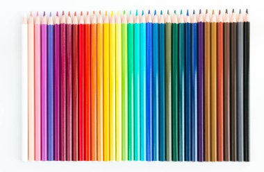 Pastel boya kalemleri ve suluboya boyalar beyaz arkaplanda izole bir şekilde dizilmişler.