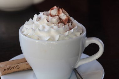 Bir fincan kahve fasulye ve siyah arka plan üzerine tarçın 