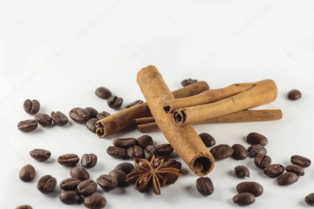 Cinnamon sticks with anise star and coffee beans on white backgr