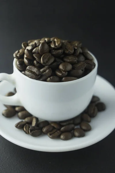 Xícara de café preto com espuma no fundo de grãos de café torrados — Fotografia de Stock