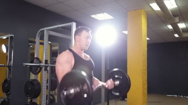 Hombre haciendo levantamiento de pesas en gimnasio — Vídeos de Stock