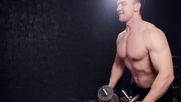 Een man met een halter in de sportschool — Stockvideo