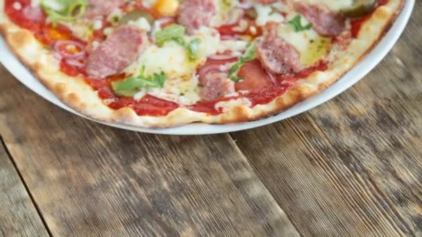 Pizza italiana servida sobre mesa de madera — Vídeos de Stock