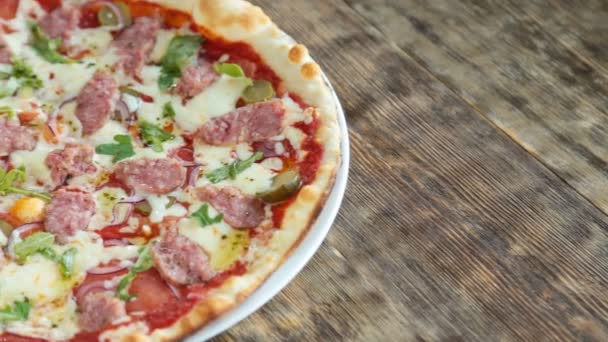 Pizza italiana servida sobre mesa de madera — Vídeos de Stock