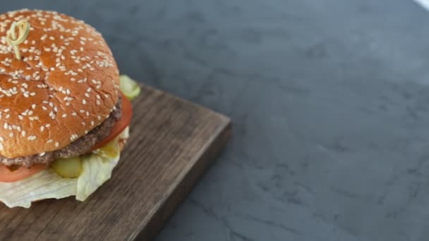 Гамбургер на деревянном фоне — стоковое видео